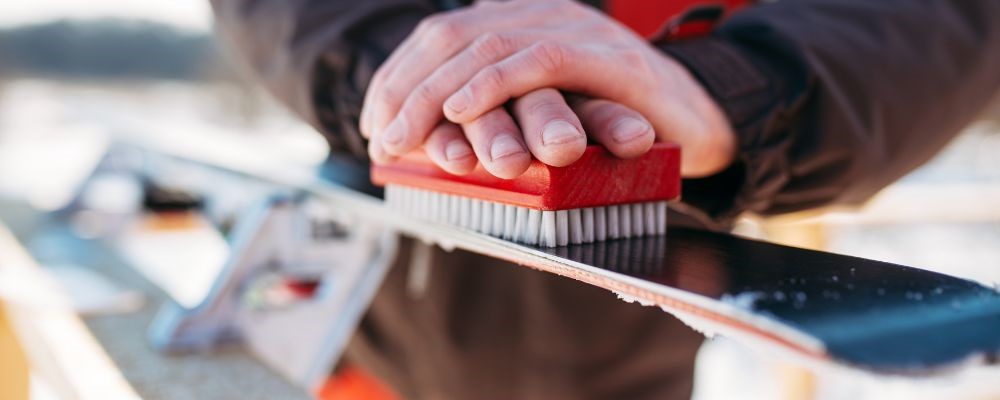 man-cleaning-his-skis